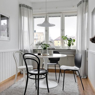 Nordisk inredning av en liten matplats, med vita väggar, mellanmörkt trägolv och beiget golv