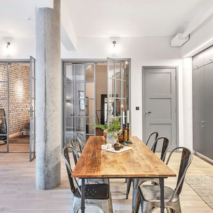 Idee per una grande sala da pranzo aperta verso il soggiorno industriale con pareti bianche, parquet chiaro e nessun camino