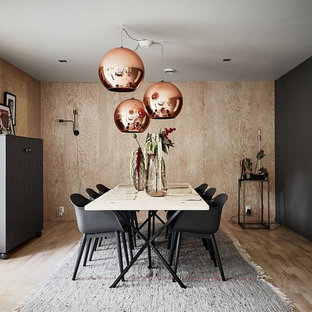 Cette image montre une grand salle à manger nordique fermée avec un sol en bois clair et un mur noir.