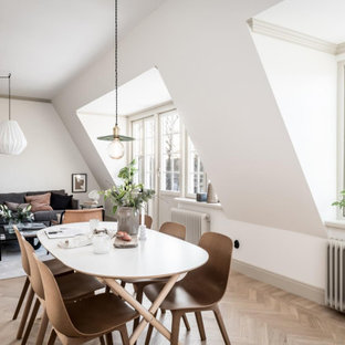 Nordisk inredning av en matplats med öppen planlösning, med vita väggar, mellanmörkt trägolv och brunt golv