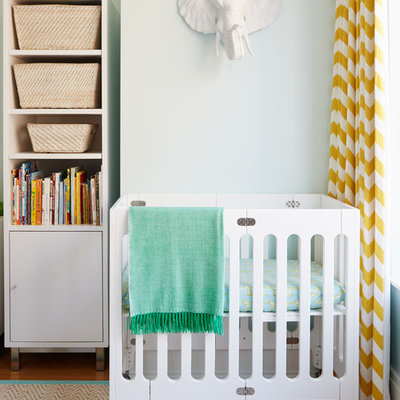 Inspiration for a transitional gender-neutral medium tone wood floor nursery remodel in New York with blue walls