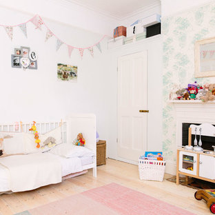Photo of a medium sized classic nursery in London with grey walls, light hardwood flooring and beige floors.