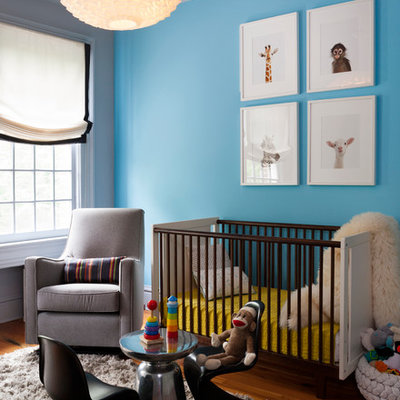 Example of a mid-sized trendy medium tone wood floor nursery design in DC Metro with blue walls