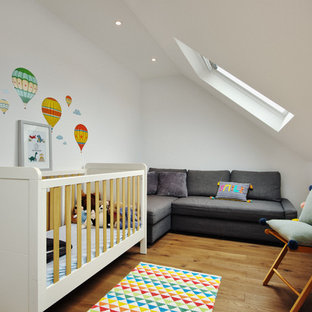 Inspiration for a scandinavian gender neutral nursery in London with white walls and medium hardwood flooring.