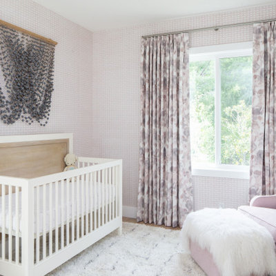Trendy girl medium tone wood floor and brown floor nursery photo in Orange County with multicolored walls