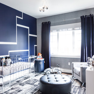 Foto di una cameretta per neonato moderna di medie dimensioni con pareti blu e parquet scuro