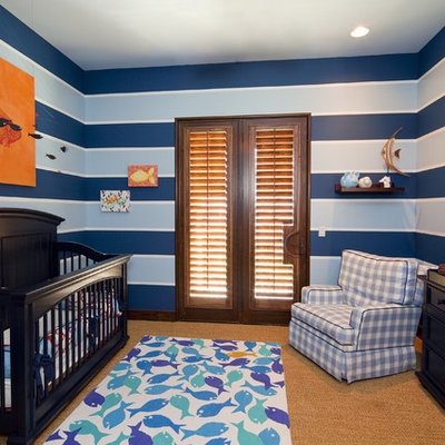 Mid-sized trendy boy carpeted nursery photo in Austin with blue walls