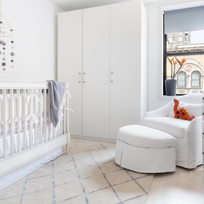 Inspiration for a mid-sized contemporary boy light wood floor and beige floor nursery remodel in New York with gray walls