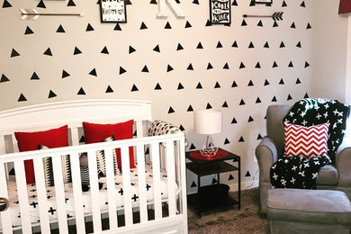 Ejemplo de habitación de bebé niño pequeña con paredes blancas y moqueta