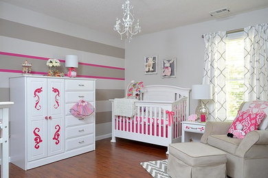 Example of a classic girl medium tone wood floor nursery design in Raleigh with multicolored walls