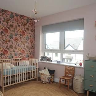 Inspiration for an eclectic nursery for girls in Edinburgh with multi-coloured walls, medium hardwood flooring and brown floors.