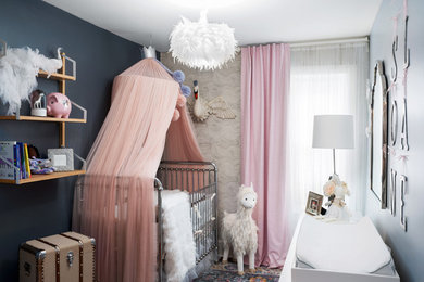 Diseño de habitación de bebé niña bohemia con paredes azules