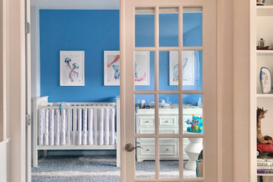 Inspiration for a mid-sized contemporary boy carpeted and multicolored floor nursery remodel in New York with blue walls
