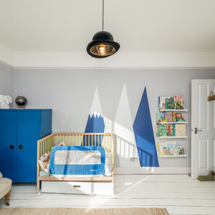 Photo of a contemporary nursery for boys in London with grey walls, painted wood flooring and white floors.