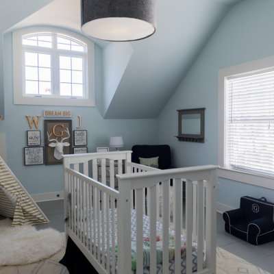 Example of a classic boy gray floor nursery design in Other with blue walls