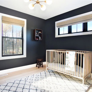 Imagen de habitación de bebé neutra nórdica, de tamaño medio, con paredes negras, suelo de madera clara y suelo beige