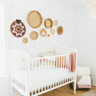 Foto de habitación de bebé niña de estilo de casa de campo, de tamaño medio, con paredes blancas, suelo de madera clara y suelo marrón