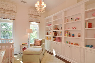 Example of a mid-sized classic girl medium tone wood floor nursery design in Chicago with beige walls