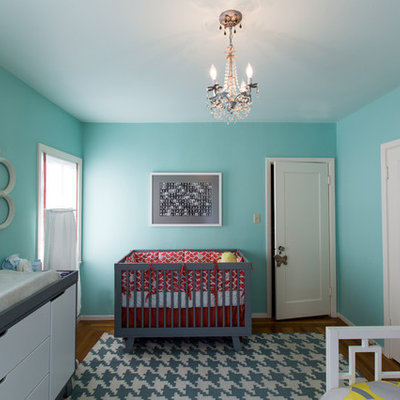 Mid-sized trendy gender-neutral medium tone wood floor nursery photo in San Francisco with blue walls