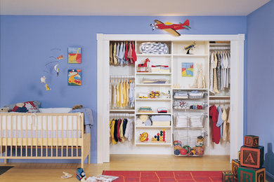Imagen de habitación de bebé niño clásica de tamaño medio con paredes azules y suelo de madera clara