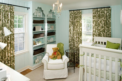 Diseño de habitación de bebé neutra tradicional con paredes azules y suelo de madera en tonos medios