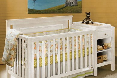 Ejemplo de habitación de bebé neutra clásica de tamaño medio con paredes amarillas y suelo de cemento
