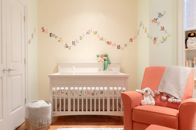 ボストンにある低価格の小さなトランジショナルスタイルのおしゃれな赤ちゃん部屋 (マルチカラーの壁、淡色無垢フローリング、男女兼用) の写真
