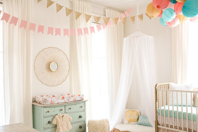 На фото: комната для малыша среднего размера в стиле шебби-шик с белыми стенами и деревянным полом для девочки с