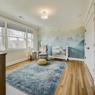 Foto di una cameretta per neonati neutra american style di medie dimensioni con pareti bianche e parquet chiaro