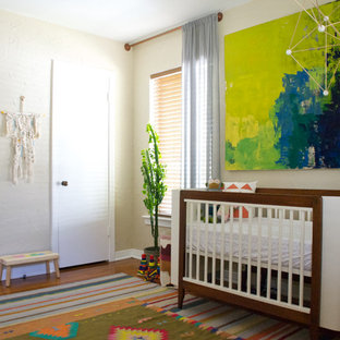 Inspiration for an eclectic gender-neutral medium tone wood floor nursery remodel in Dallas with beige walls