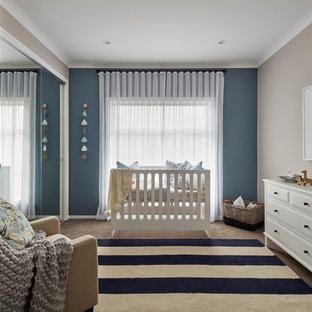 This is an example of a beach style gender-neutral nursery in Other with beige walls, carpet and beige floor.