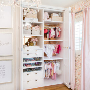 Inspiration for a mid-sized timeless girl medium tone wood floor nursery remodel in Los Angeles with white walls