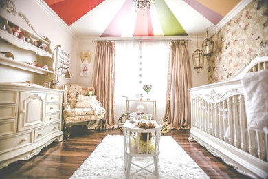 Foto de habitación de bebé niña tradicional de tamaño medio con suelo de madera oscura y paredes blancas