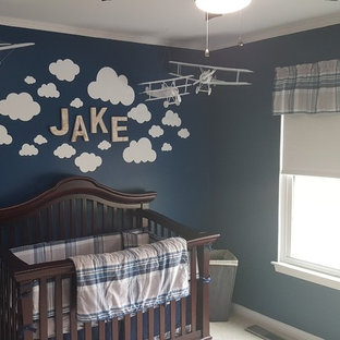 Example of a mid-sized classic boy carpeted and beige floor nursery design in Cincinnati with blue walls