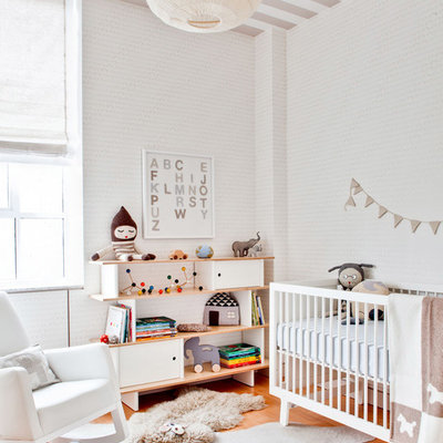 Trendy gender-neutral light wood floor nursery photo in New York with white walls