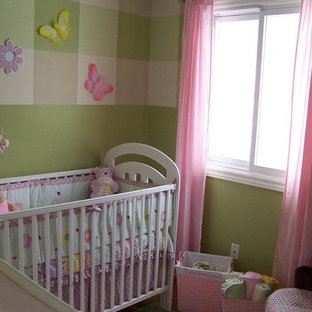 Foto di una piccola cameretta per neonata stile shabby con pareti verdi e pavimento in laminato