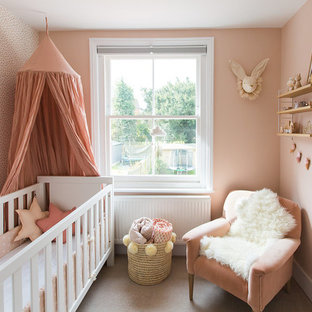 Inspiration for a small scandi nursery for girls in Surrey with pink walls, carpet and beige floors.