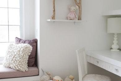 Nursery - small traditional girl medium tone wood floor nursery idea in Calgary with white walls