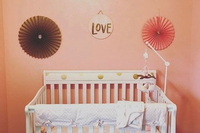Ejemplo de habitación de bebé niña minimalista pequeña con paredes rosas, moqueta y suelo beige