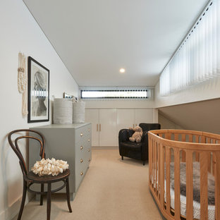 Photo of a contemporary gender-neutral nursery in Sydney with beige walls, concrete floors and beige floor.