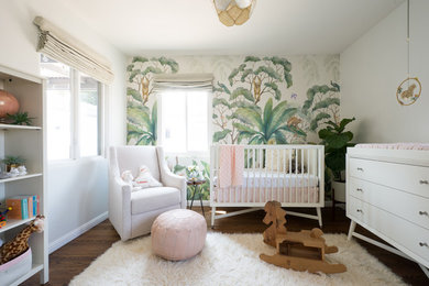 Diseño de habitación de bebé niña ecléctica de tamaño medio con suelo de madera en tonos medios