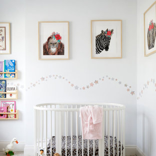 Inspiration for a medium sized classic nursery for girls in London with white walls.
