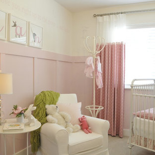 Diseño de habitación de bebé niña tradicional, de tamaño medio, con paredes rosas, moqueta y suelo gris