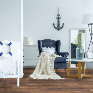 Idee per una piccola cameretta per neonati neutra stile marinaro con pavimento in laminato e pavimento marrone