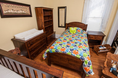 Neutrales Babyzimmer mit beiger Wandfarbe und braunem Holzboden in Sonstige