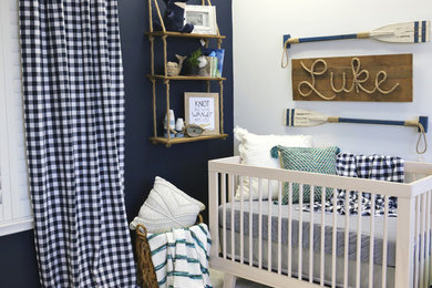 Inspiration for a small coastal boy laminate floor and beige floor nursery remodel in Austin with blue walls