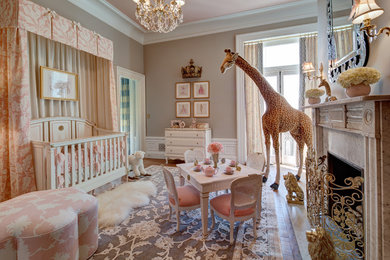 Diseño de habitación de bebé niña clásica grande con paredes beige y suelo de madera en tonos medios
