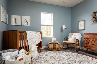 オーランドにある低価格の小さなミッドセンチュリースタイルのおしゃれな赤ちゃん部屋 (青い壁、クッションフロア、男女兼用、グレーの床) の写真