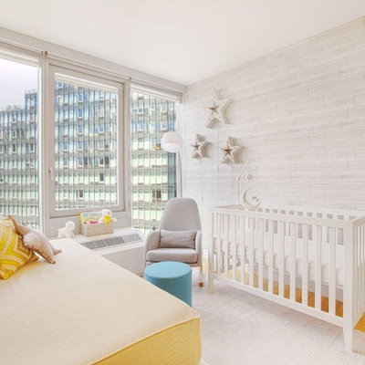 Example of a small trendy gender-neutral light wood floor and brown floor nursery design in New York with gray walls