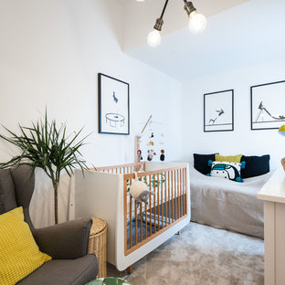 Inspiration for a contemporary gender neutral nursery in London with white walls, carpet and beige floors.